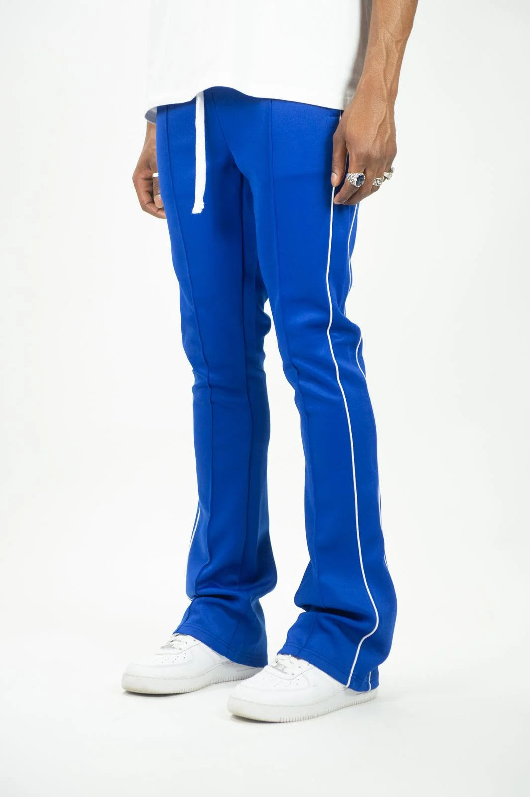 Man wearing blue Rebel Minds stacked fit track pants with white side stripes and white sneakers